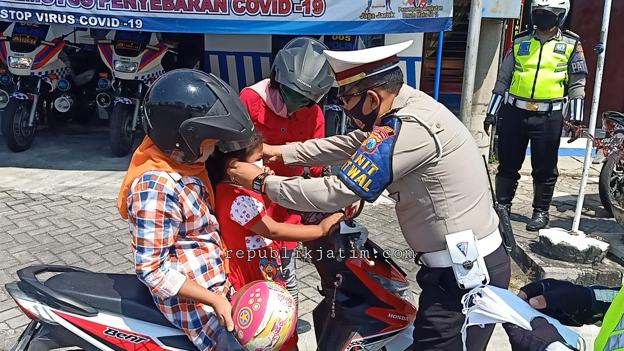 Kanit Turjawali Satlantas Polres Ngawi memberikan masker gratis bagi pengendara yang tak pakai masker
